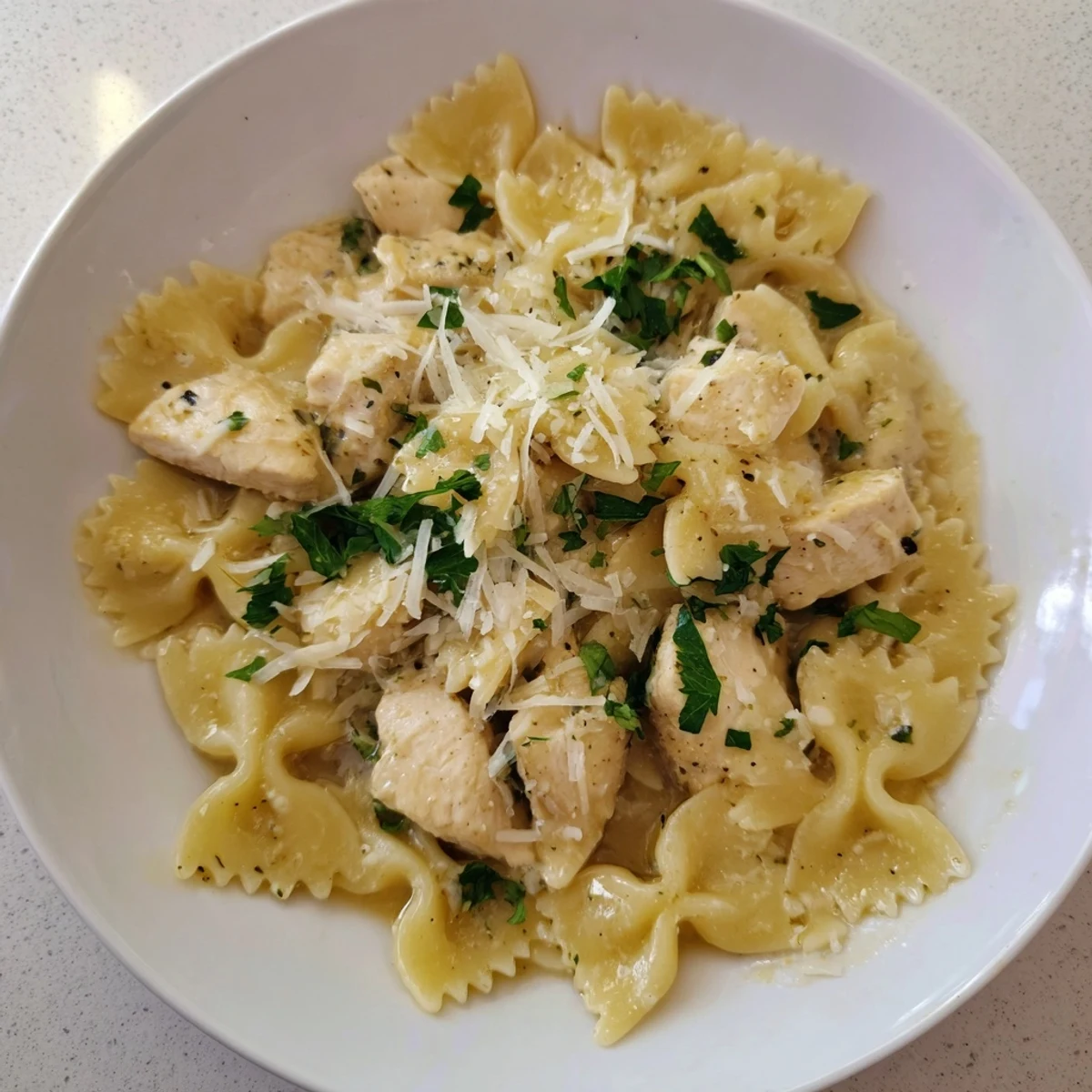 Golden mozzarella cheese melting over the flavorful Mozzarella Garlic Butter Chicken Bowties pasta dish.