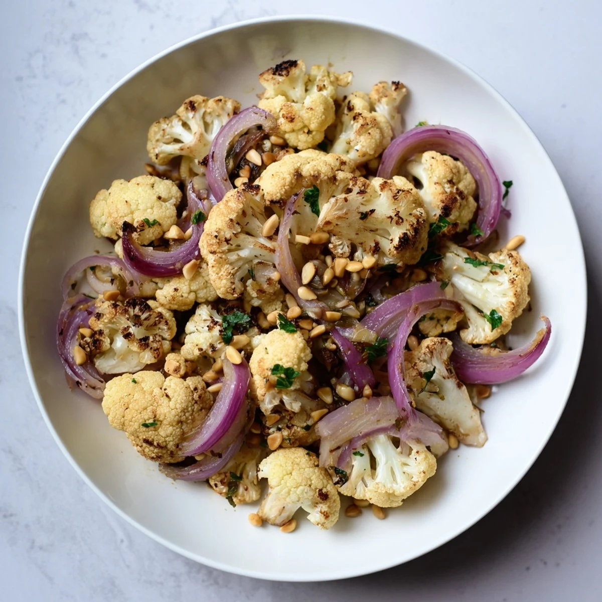 Fragrant and flavorful, this Warm Roasted Cauliflower salad features a bright lemon dressing and toasted pine nuts.