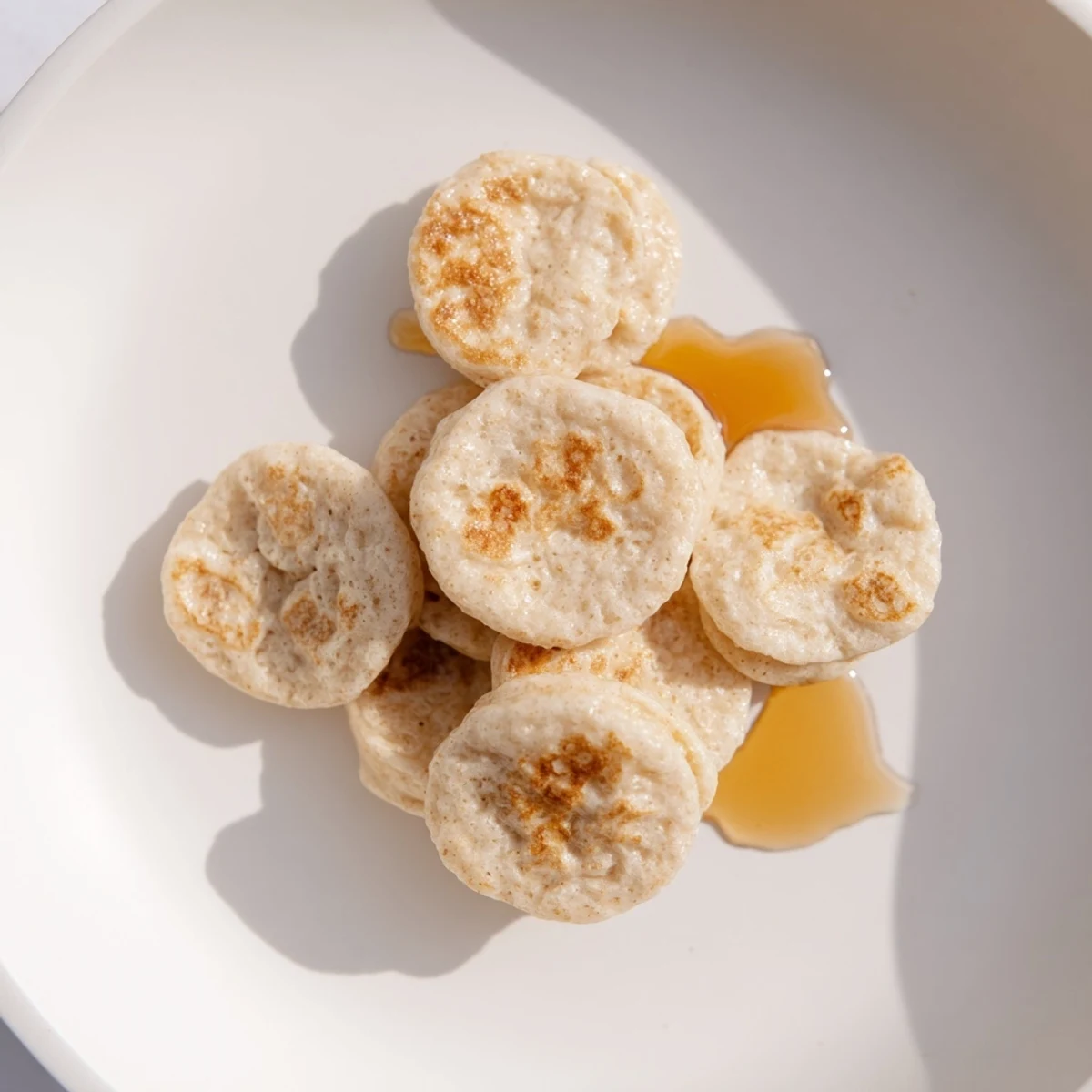 Miniature pancake cereal: a bowl filled with tasty, bite-sized pancakes ready to be enjoyed.