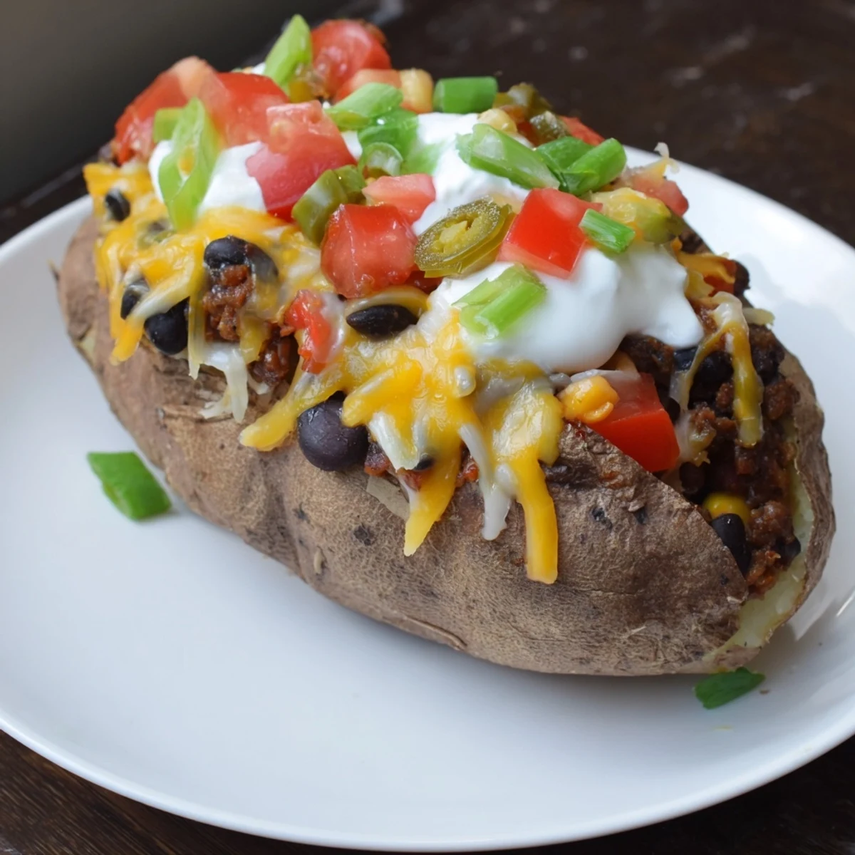Fluffy Loaded Baked Potato with chili, cheese, and fresh toppings, ready to enjoy.