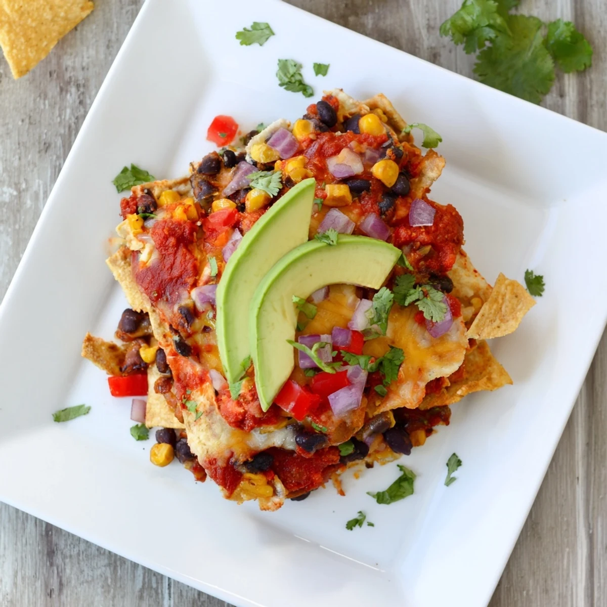 Quick Black Bean and Corn Tortilla Casserole bubbling with melted cheese and ready to serve with fresh cilantro.