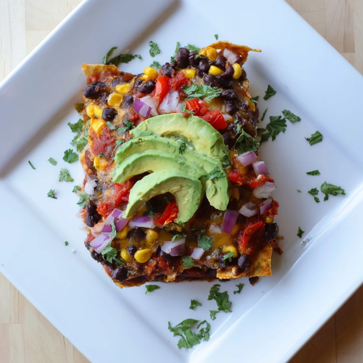 A close-up of a warm Quick Black Bean and Corn Tortilla Casserole, showing corn, cheese, and salsa layers.