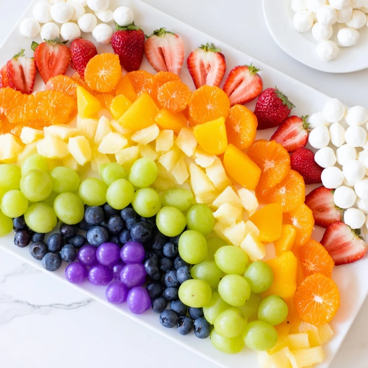 Colorful rainbow cloud snack board, refreshing fruit and veggie arrangement perfect for healthy snacking.