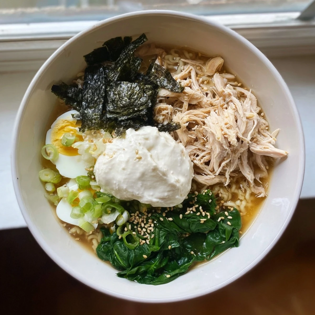 Steaming bowl of creamy Chicken Ramen with Kewpie Mayo, topped with a soft egg, ready to enjoy.