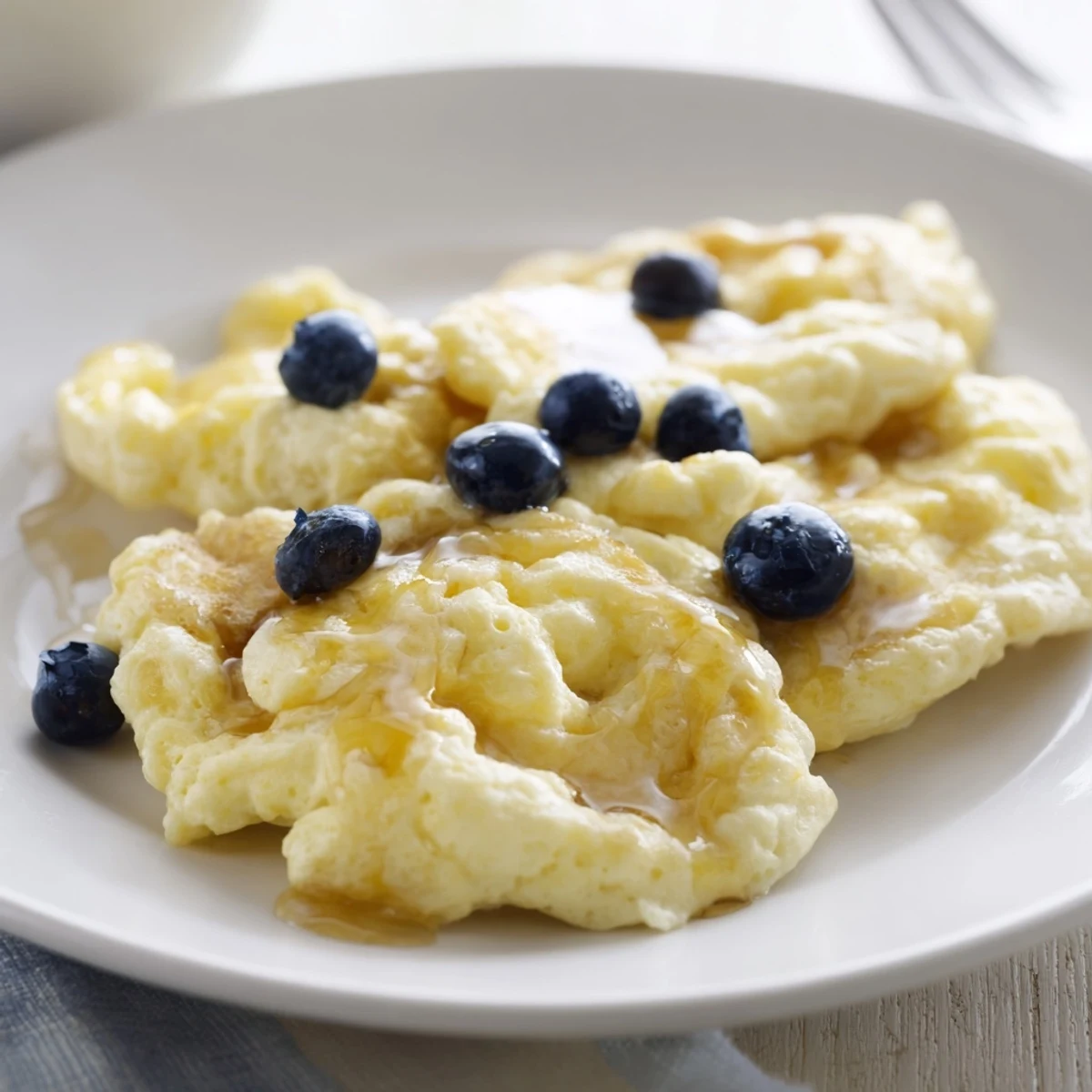 This image shows soft, tender fluffy scrambled pancakes, perfect served with fresh fruit.