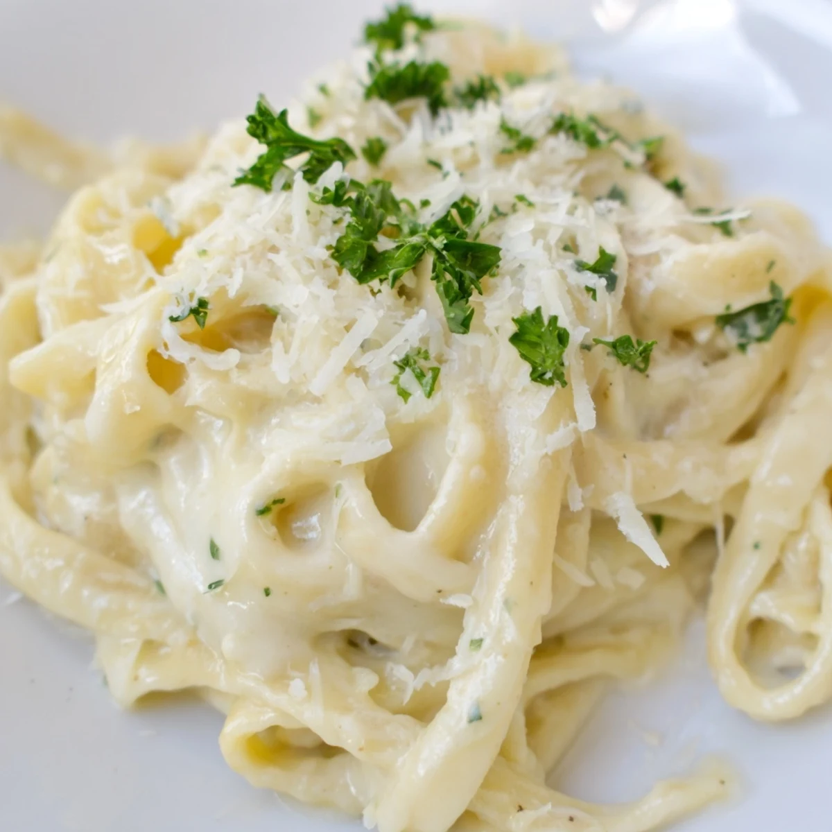 Creamy roasted cauliflower alfredo sauce coats fettuccine, garnished with fresh parsley and extra Parmesan for a comforting Italian-inspired dinner.