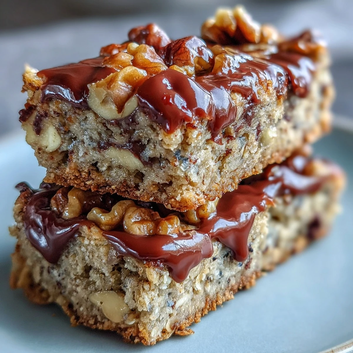 Golden-baked Chunky Monkey Protein Oat Bars studded with chocolate chips and chopped walnuts on a wooden board.