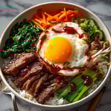 Korean Beef Bibimbap Bowls: Sizzling beef over steamed rice with a spicy gochujang sauce.