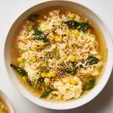 Creamy, flavorful, and quick, a close-up photo of Elevated Ramen Egg Drop Soup with fresh garnishes.