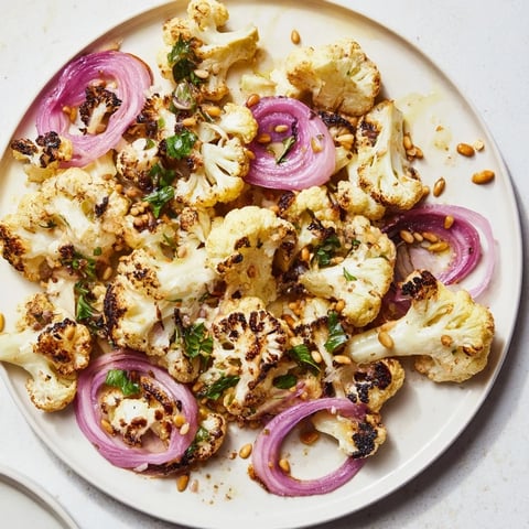 Golden-brown Warm Roasted Cauliflower salad, tossed with vibrant lemon pine-nut dressing, ready to enjoy.