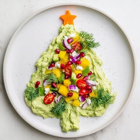 Fluffy whipped avocado Christmas tree dip decorated with colorful vegetables, perfect for holiday gatherings.