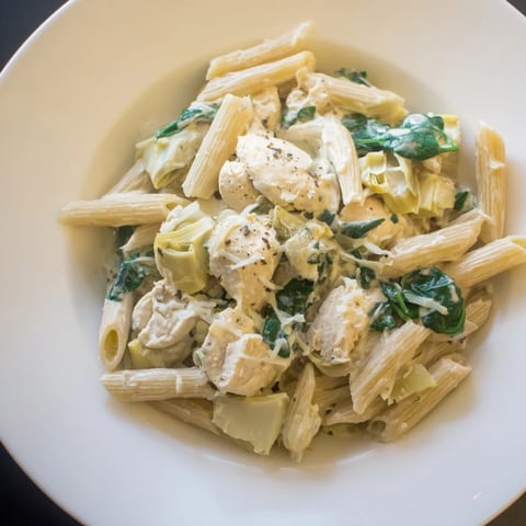 Steaming Creamy Spinach Artichoke Protein Pasta Skillet, a one-pan meal, bubbling with sauce.