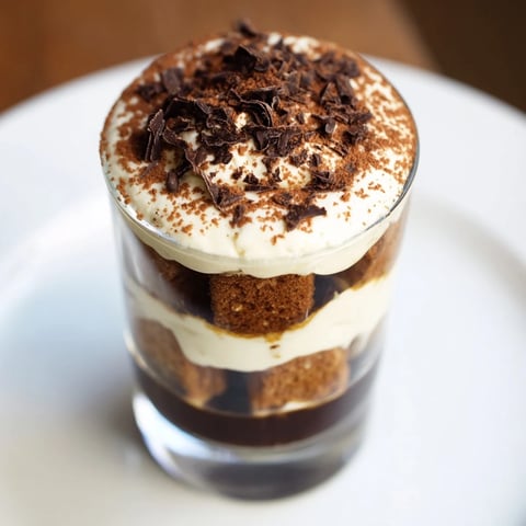 Deconstructed Tiramisu Shots in shot glasses: Layers of creamy mascarpone and coffee-soaked biscuits, dusted with cocoa.
