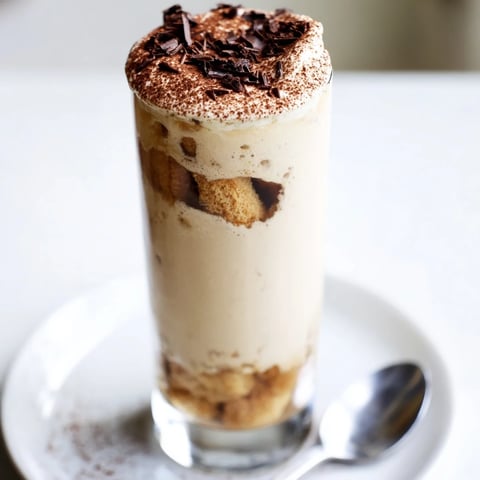 A chilled Tiramisu Latte topped with cocoa powder, a decadent coffee dessert to savor.