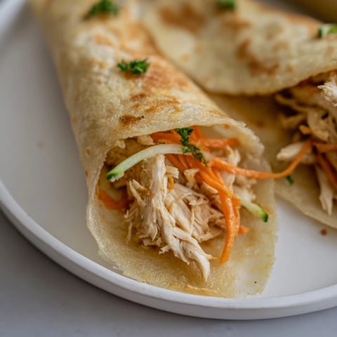 Golden-brown Garlicky Pulled Chicken Wraps feature crispy wrappers holding flavorful, garlic-infused chicken and fresh veggies.