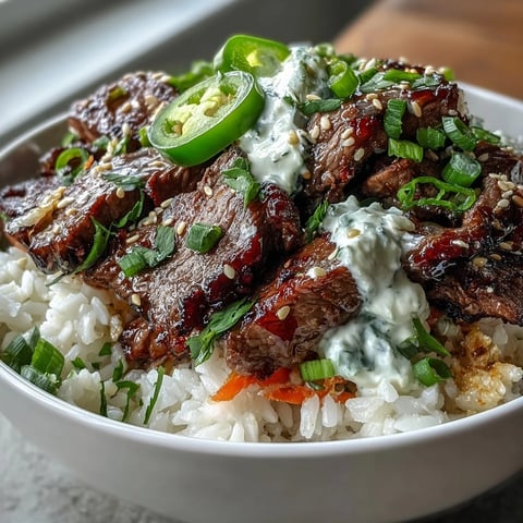 A vibrant Korean Beef Power Bowl with sesame-ginger beef, fluffy rice, pickled carrots, cucumber, jalapeños, and creamy sriracha mayo, ready to serve.