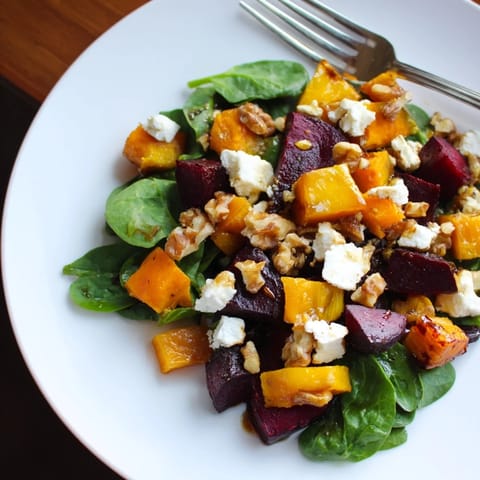 Warm, colorful photo: a fresh Roasted Beet, Butternut & Spinach Salad with balsamic dressing.