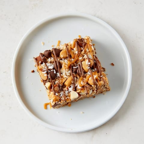 Chewy, decadent squares of 7-Layer Magic Bars, drizzled with sweet caramel and flaky sea salt.
