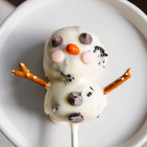 Festive Oreo Snowman Cake Pops, adorable snowmen on sticks, perfect for a party dessert.