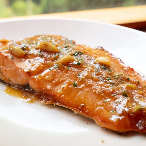 Roasted Honey Garlic Glazed Salmon brushed with buttery glaze, served alongside fluffy white rice and steamed green beans for dinner.