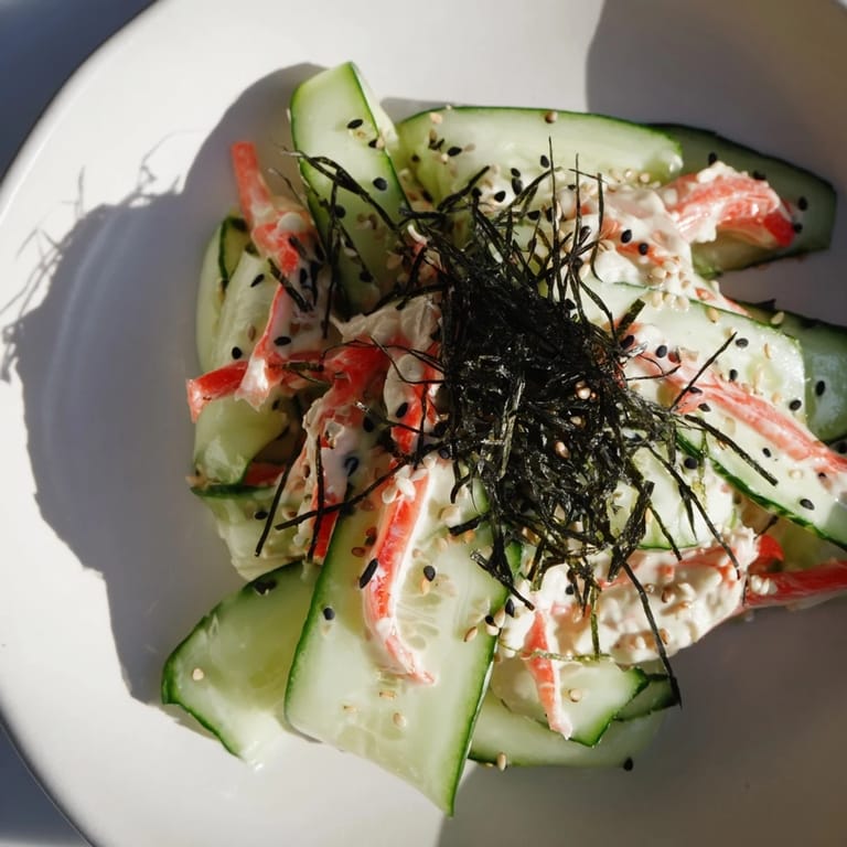 This California Roll Cucumber Salad features a beautiful presentation, topped with sesame seeds and nori strips.